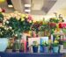 A colorful array of flowers in various vases inside a modern florist shop.